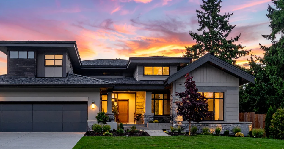 Modern home at dusk with warm interior lighting